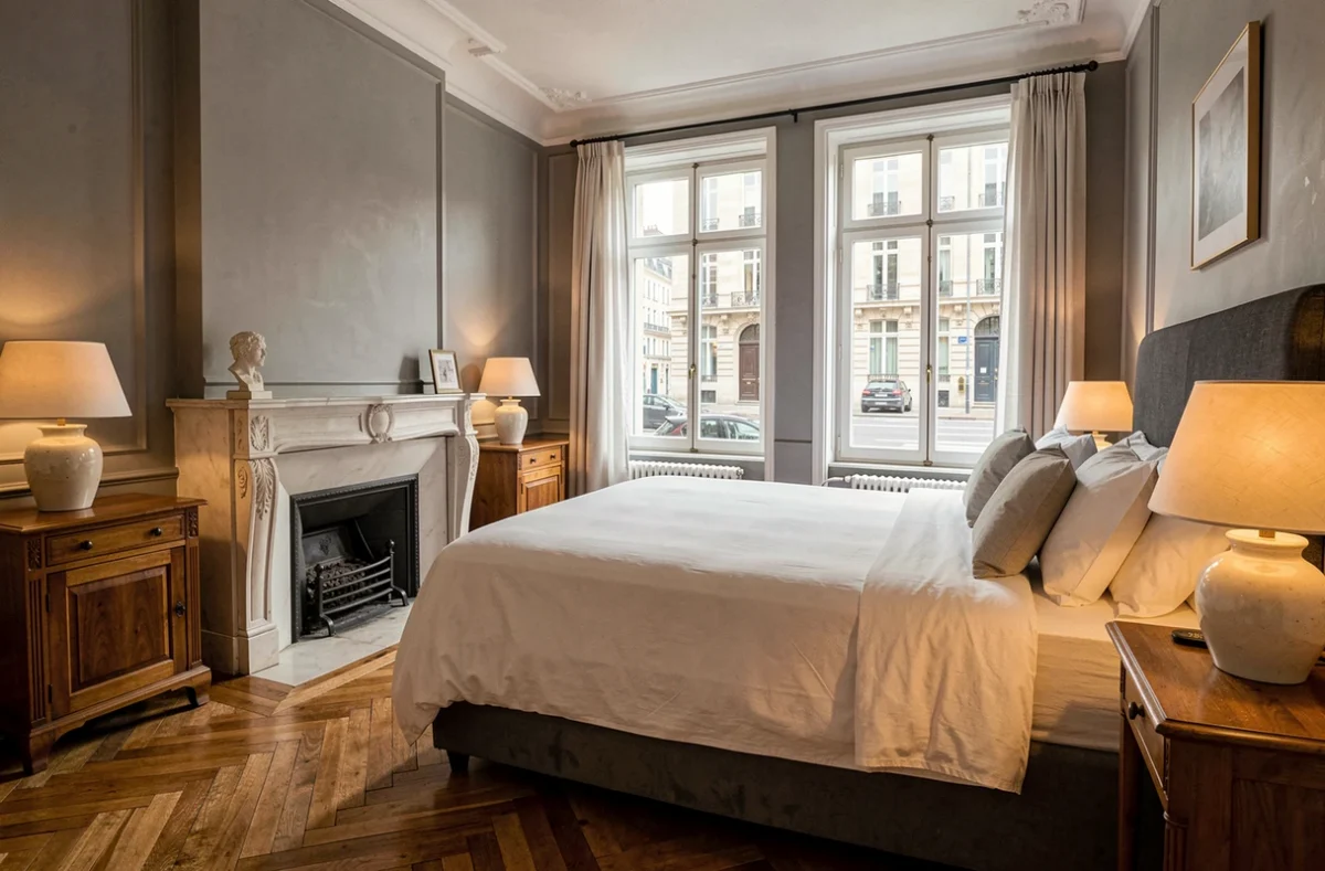 Chambre classique de l'Hôtel de la Paix à Lille avec lit king-size, parquet et cheminée ancienne